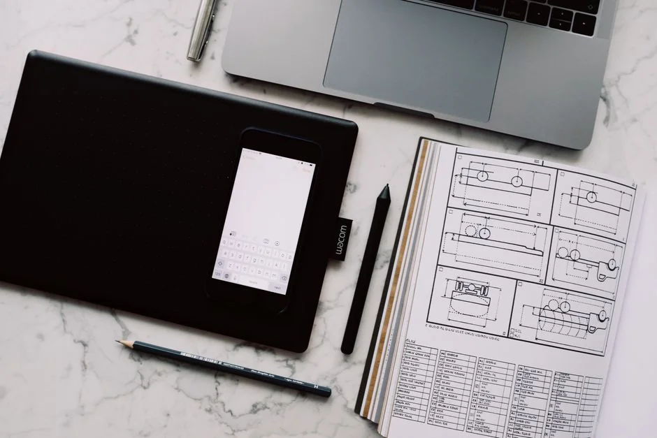 Business professional using a tablet and laptop with a hot drink, focusing on digital content review.